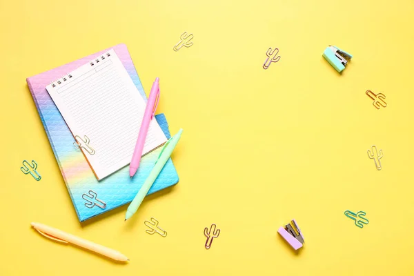 由不同的学校文具和黄色背景的空白笔记本制成的框架 — 图库照片
