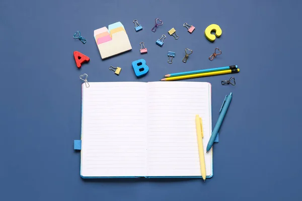 青の背景に異なる学校の文房具や空白のノート — ストック写真