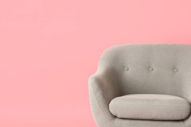 Pembe arka planda gri koltuk