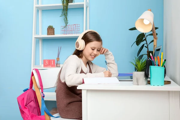 Kulaklıklı Küçük Kız Evde Ders Çalışıyor — Stok fotoğraf