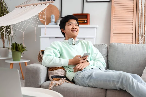 Ung Asiatisk Man Använder Mobiltelefon Sin Lediga Dag Hemma — Stockfoto