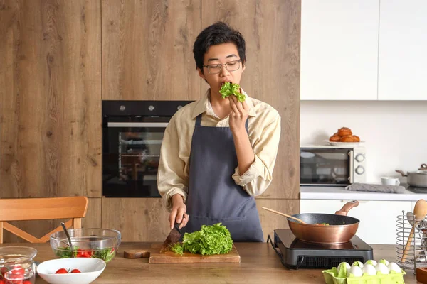 Young Asian Man Eating Lettuce Kitchen — Stock Photo, Image