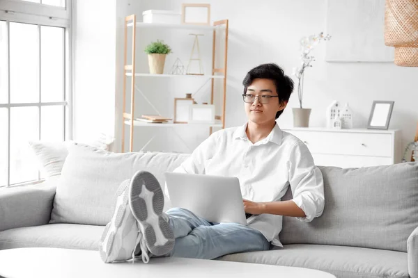 stock image Young Asian man using laptop on his day off at home