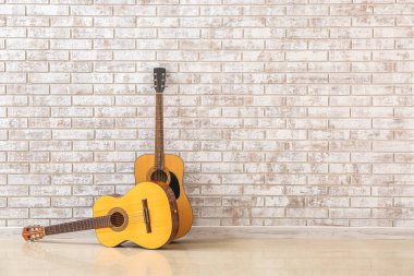 Tuğla duvarın yanında iki gitar