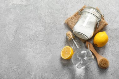 Sirke, fırça, kabartma tozu ve arkaplanda limon.