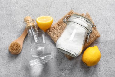 Sirke, fırça, kabartma tozu ve arkaplanda limon.