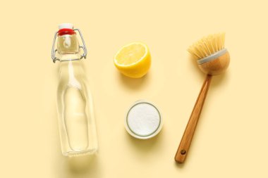Bir şişe sirke, kabartma tozu, fırça ve limon.