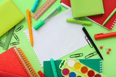 Yeşil arkaplanda boş defter bulunan farklı kırtasiyeden yapılmış çerçeve