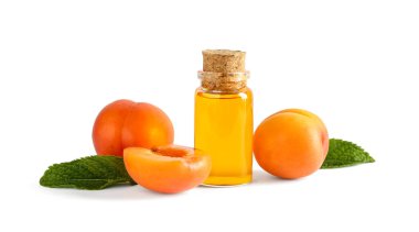 Beyaz arka planda izole edilmiş bir şişe gerekli yağ ve olgun kayısılar.