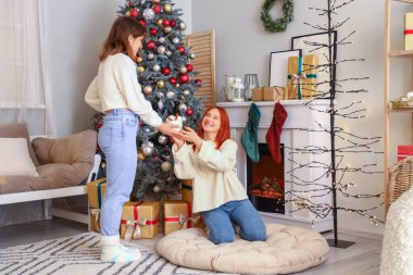 Noel arifesinde şöminenin yanında kakaolu genç kadınlar