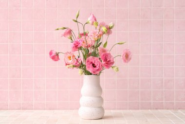 Açık fayanslı güzel pembe Eustoma çiçekleri olan vazo