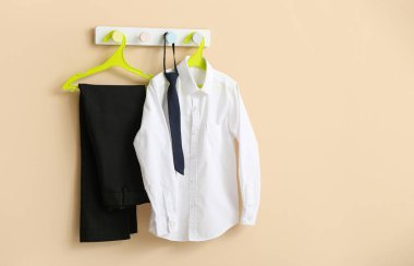 Bej duvarda asılı şık okul üniforması.