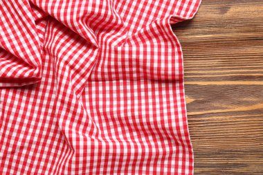 Ahşap arka planda kırmızı kareli peçete, yakın plan