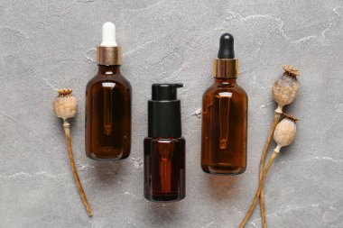 Kozmetik ürünleri ve grunge arka planında kurutulmuş haşhaş başlıklarıyla kompozisyon