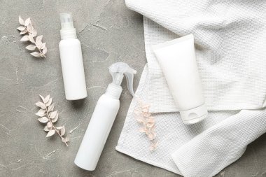 Kozmetik ürünleri, kurumuş bitkiler ve grunge arka planında temiz havlular içeren kompozisyon
