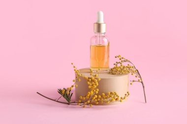 Pembe arka planda gerekli yağ ve mimoza çiçekleriyle podyum