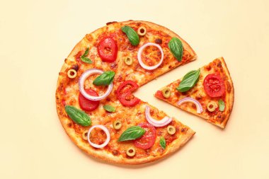 Zeytinli, domatesli ve sarı arka planda fesleğenli lezzetli pizza.