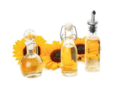 Beyaz zemin üzerinde ayçiçeği yağı olan şişeler ve sürahiler.