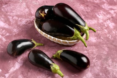 Pembe arka planda taze patlıcan sepeti.