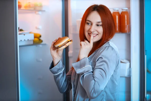 Giovane Donna Con Gustoso Hamburger Mostrando Silenzio Gesto Vicino Frigo — Foto Stock