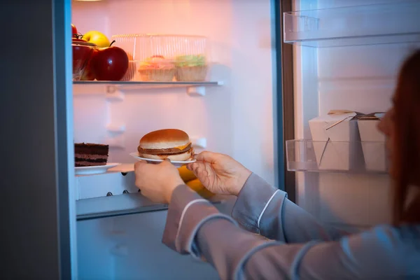 Junge Frau Holt Nachts Leckeren Burger Aus Kühlschrank Küche Nahaufnahme — Stockfoto
