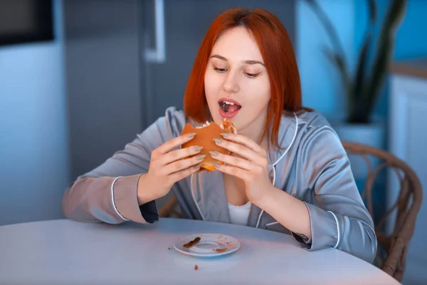 Geceleri Mutfakta Hamburger Yiyen Genç Bir Kadın — Stok fotoğraf