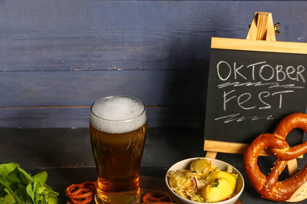 一杯冰镇啤酒 一块写有 Oktoberfest 字样的黑板和各种小吃放在桌上 — 图库照片