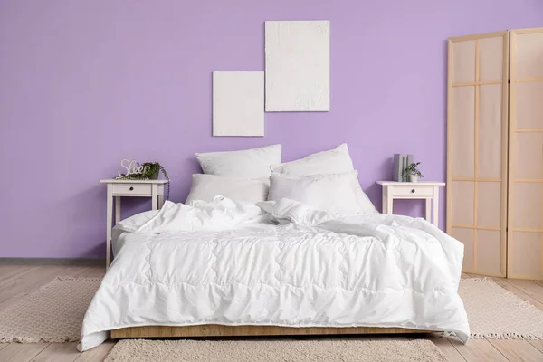 快適なベッド 白い枕 ベッドサイドテーブルと折りたたみスクリーン付きのスタイリッシュなベッドルームのインテリア — ストック写真