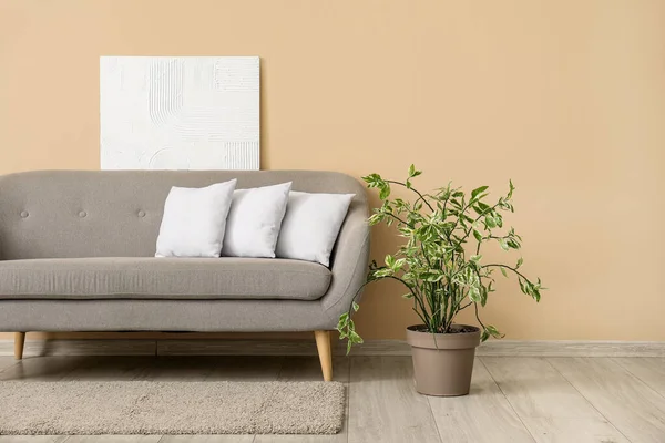 ベージュの壁の近くに白い枕とグレーのソファ — ストック写真