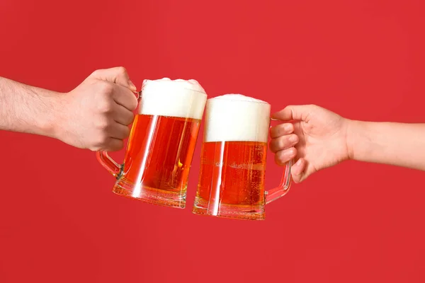 Mężczyzna Kobieta Kubkami Zimnego Piwa Brzęczące Czerwonym Tle — Zdjęcie stockowe