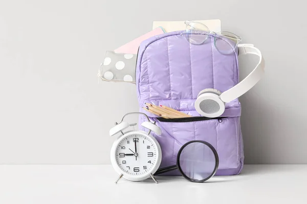 Purple School Backpack Different Stationery Alarm Clock White Table Wall — Stock Photo, Image