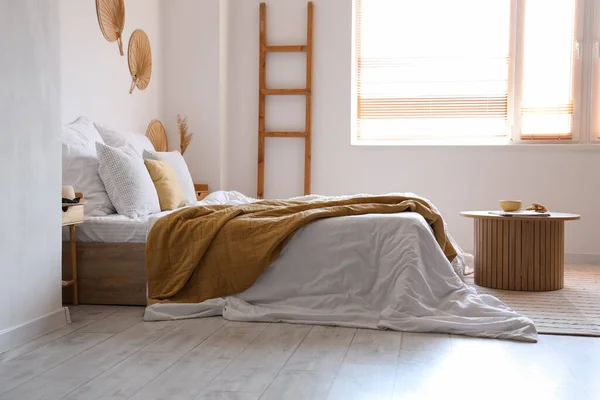 Уютная Кровать Белым Одеялом Журнальным Столиком Интерьере Светлой Спальни — стоковое фото