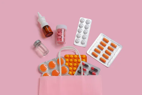 ショッピングバッグで異なる丸薬でピンクの背景 — ストック写真