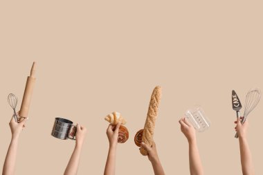 Pişirme aletleri ve bej arka planda farklı hamur işleri olan kadın elleri.