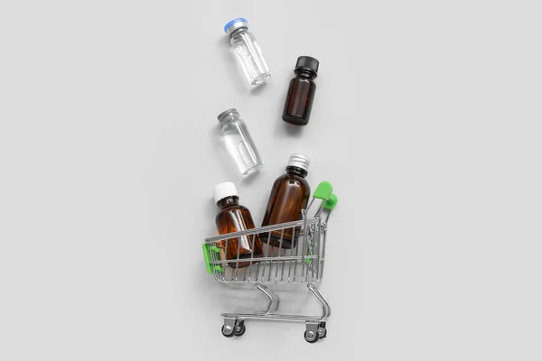 Mini Carrello Della Spesa Con Diverse Bottiglie Medicinali Sfondo Grigio — Foto Stock