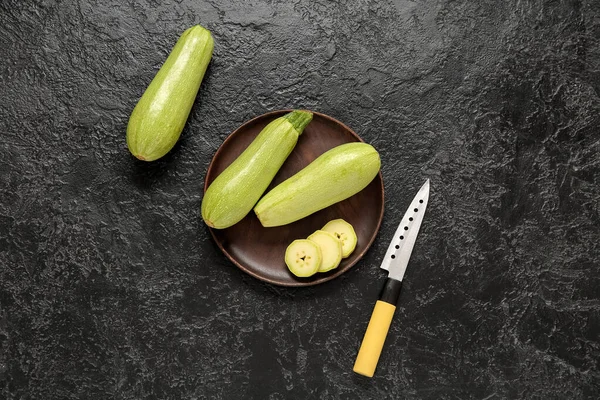 stock image Plate with fresh green zucchini on black background