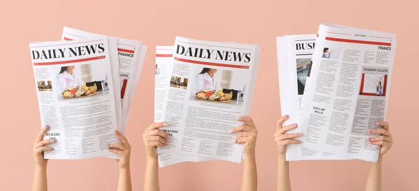 ピンクの背景に新聞と女性の手 — ストック写真