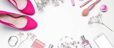 Makyaj malzemelerinden yapılmış çerçeve, kadın aksesuarları, cep telefonu ve beyaz arka planda çingene çiçekleri