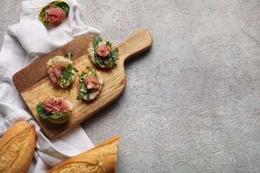 Ispanaklı lezzetli jamon bruschettalar ve grunge arkaplanda roka.