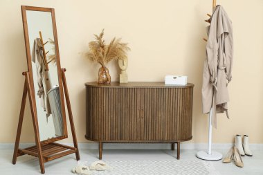 Çekmeceler, aynalar ve askılar. Koridordaki bej duvarın yanında.