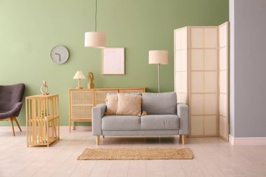 Modern oturma odası içi gri kanepe, kabine ve katlanır ekran ile