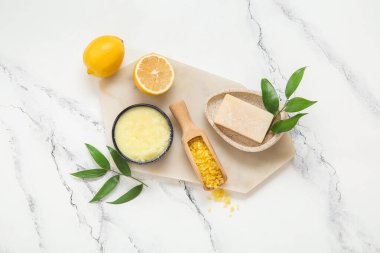 Bir kase limonlu vücut fırçası, sabun ve deniz tuzu ve grunge beyaz arka planda.