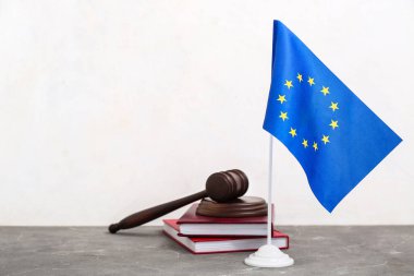Hakimler tokmak, hukuk kitapları ve Avrupa Birliği bayrağı gri masada