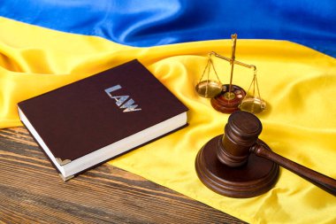 Yargıç tokmağı, hukuk kitabı ve Ukrayna bayrağında adalet terazisi.