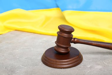 Hakimin tokmağı ve Ukrayna bayrağı gri masada.