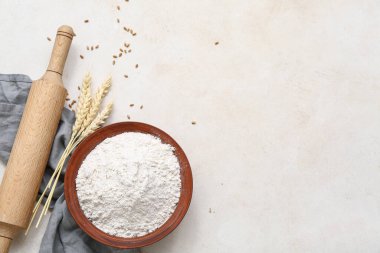 Buğday unu, dikenler ve beyaz masa üzerinde merdane.