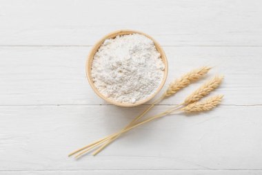 Kasede buğday unu ve beyaz ahşap arka planda dikenler.