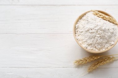 Kasede buğday unu ve beyaz ahşap arka planda dikenler.