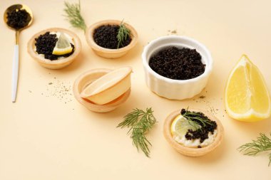 Bej arka planda siyah havyarlı lezzetli tartlar.