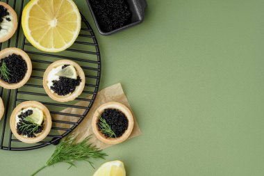 Yeşil arka planda siyah havyarlı lezzetli tartların ızgarası.